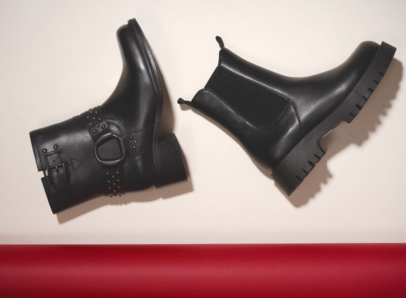 2 leather ankle boots lined up. One biker style and one Chelsea boot